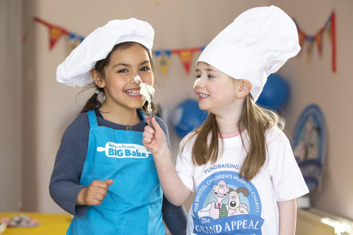 Two children playing while baking a cake