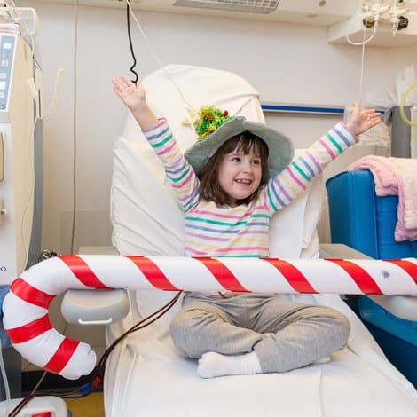 girl in hospital smiling with christmas hat