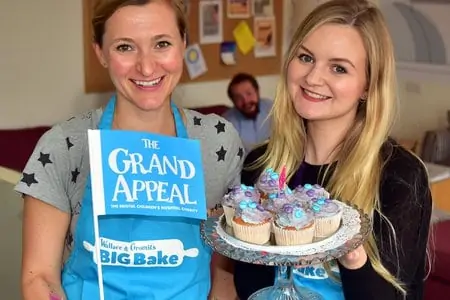 two women holding flag and cupcakes