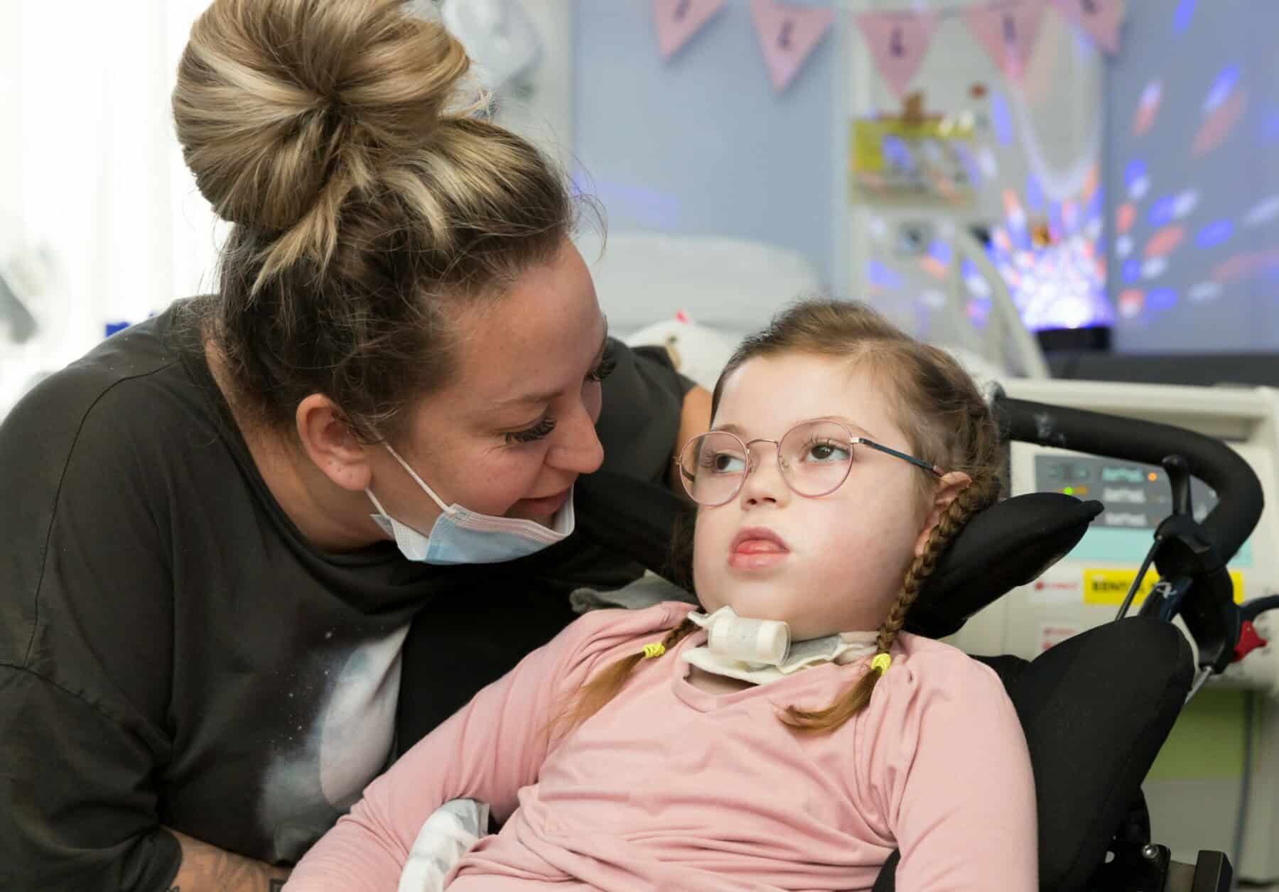 Mother next to their child who is in a wheelchair