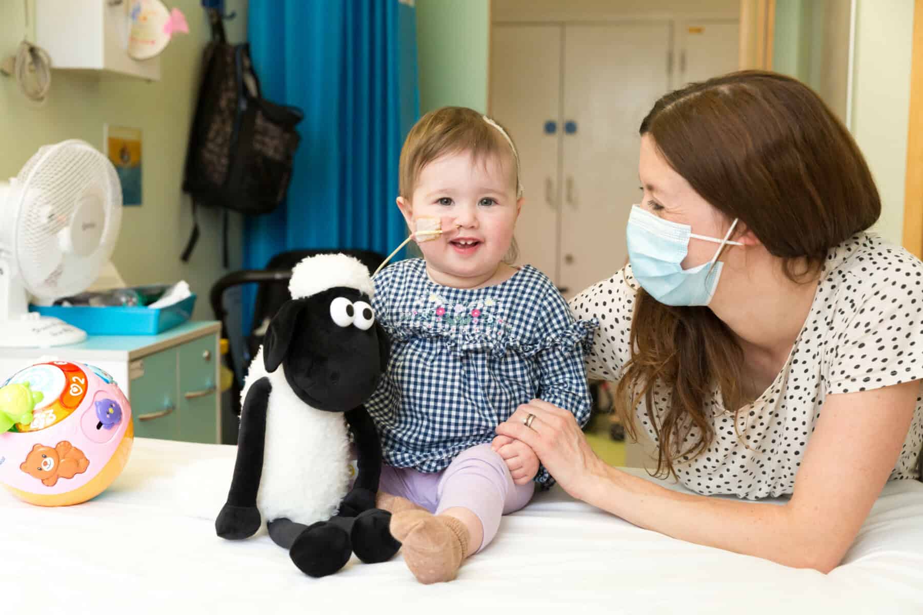 A little girl with her mother and a cuddly toy