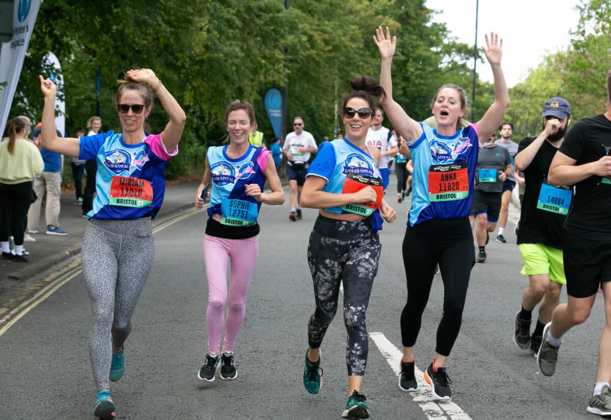 Four women running on a road