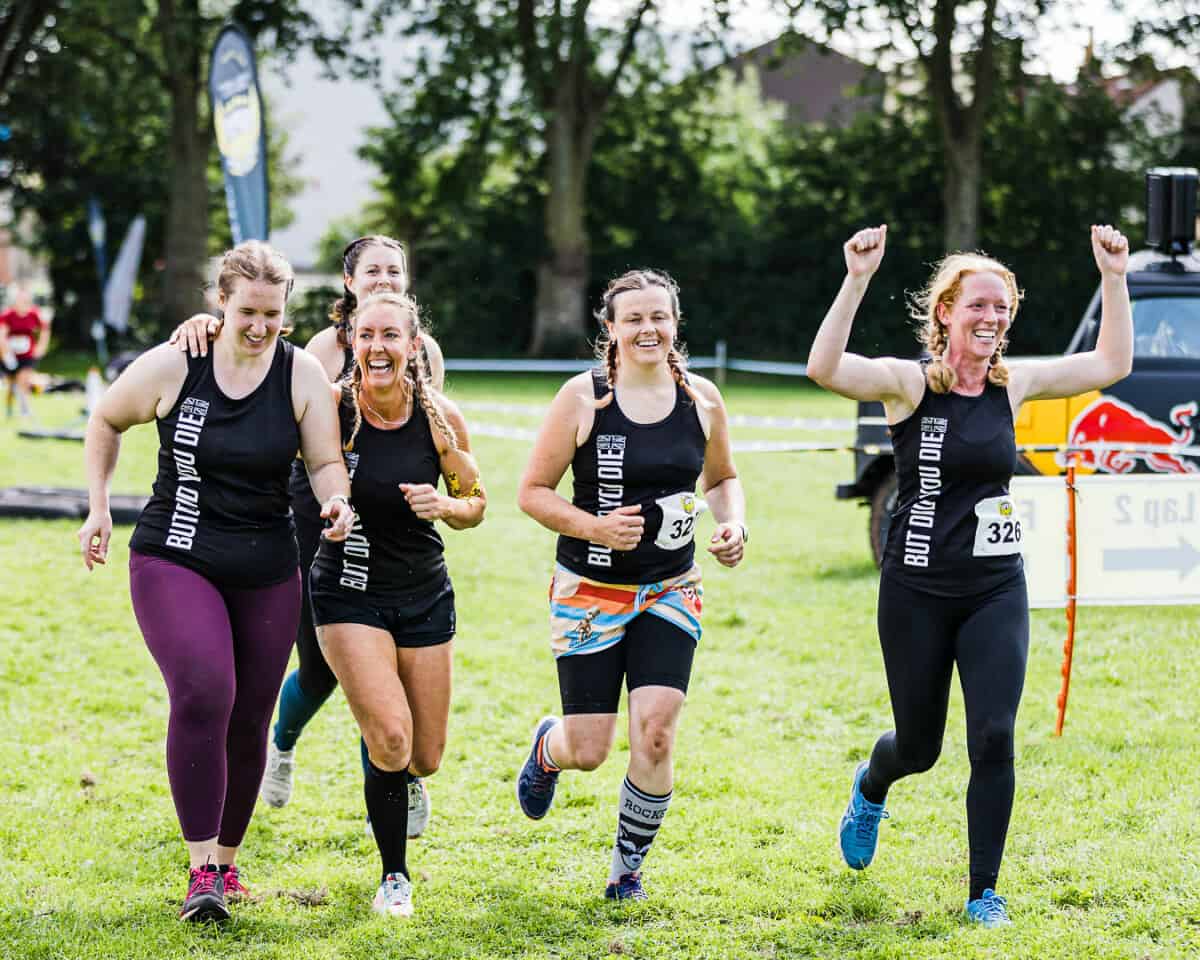 Four women running in an obstacle course