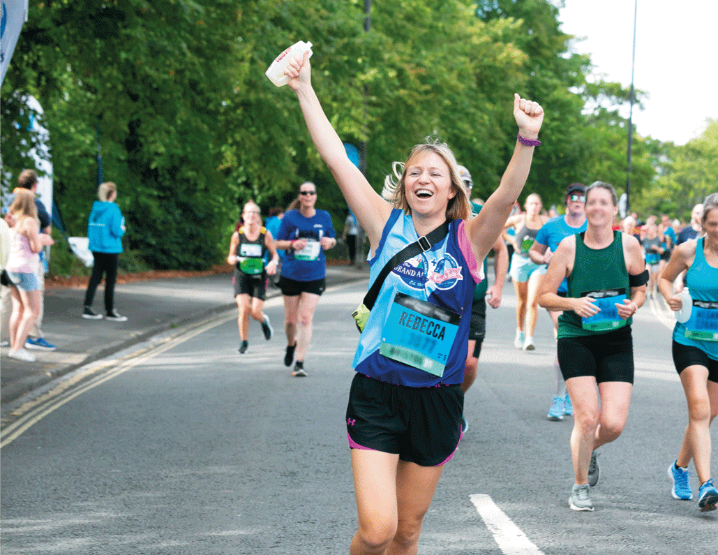 A woman holding up her arms as she runs