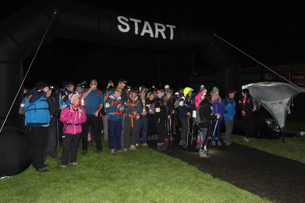 A group of climbers at the base of Mount Snowdon with a 'start' banner above their heads.