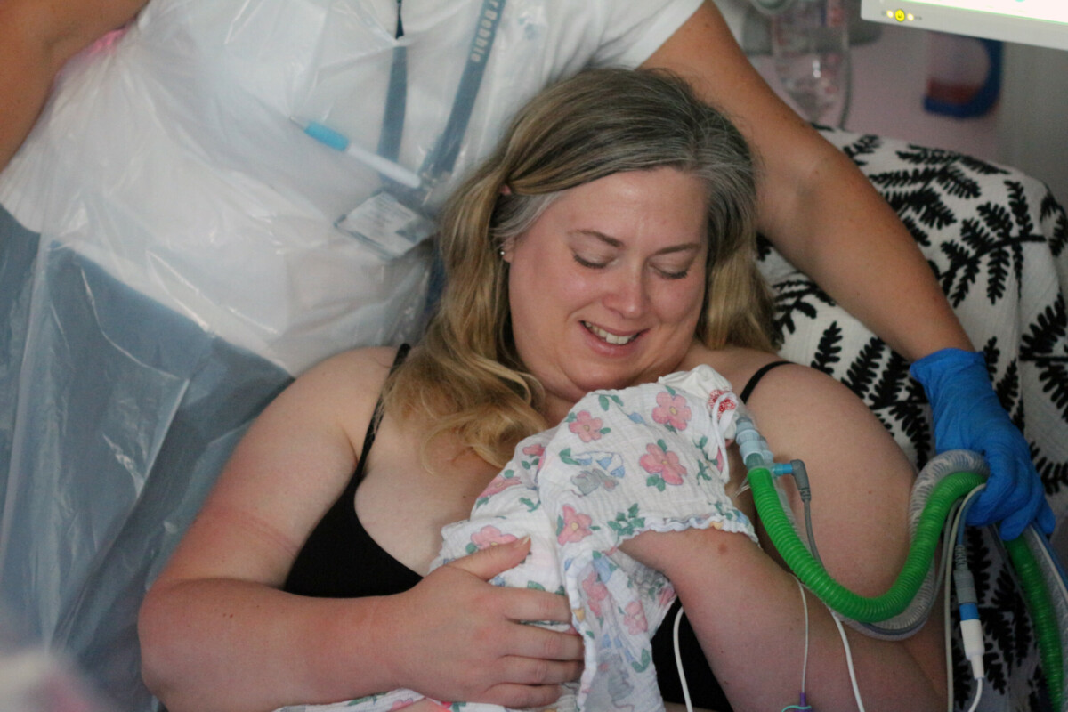 A mum practicing the skin-to-skin technique kangaroo care with baby.