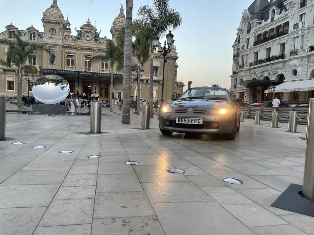 An image of Tiffany, the bust rally car, outside Monte Carlo Casino.