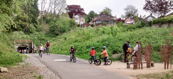 The two tunnels greenway which is the shared-use path that connects the city of bath and the midford valley. Kids are riding bikes under the tunnel. 