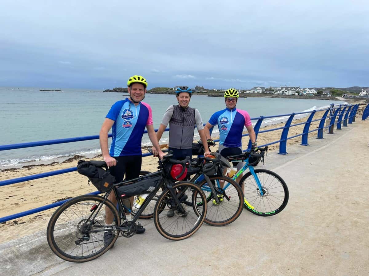 A group of men with bicycles on a beach.