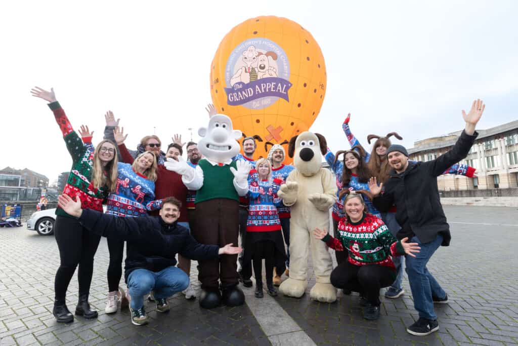 Wallace & Gromit and the Jingle Jam team in front of Wallace & Gromit's Moon Rocket hot air balloon.