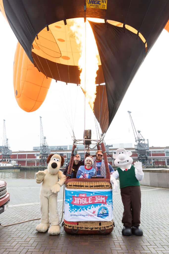 Wallace & Gromit and the team in front of Wallace & Gromit's Moon Rocket hot air balloon.