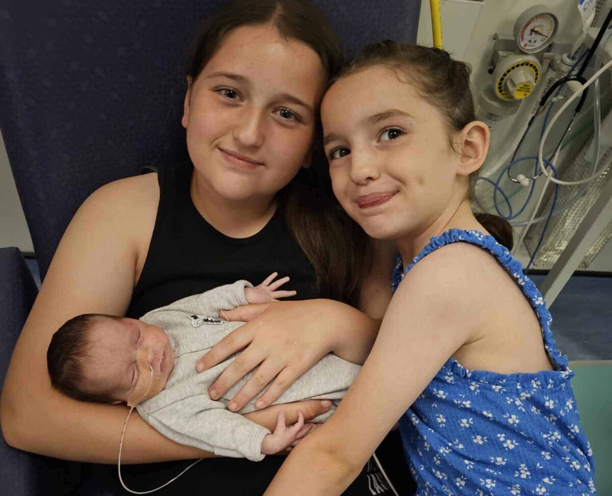 Lenny-Rose as a baby being held by her two older sisters