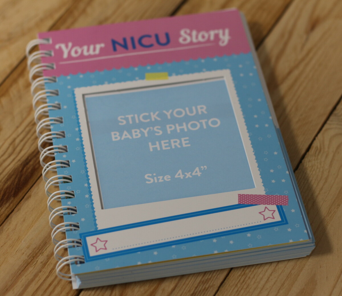 A blue and pink book that reads 'Your NICU Story', with a space for a photo to go on the front.