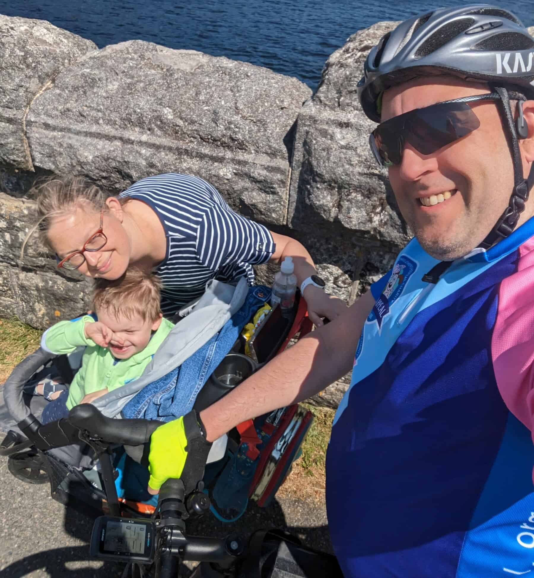 Cyclist dad training for the London to Amsterdam bike ride in a Grand Appeal t-shirt, pictured with his wife and son.