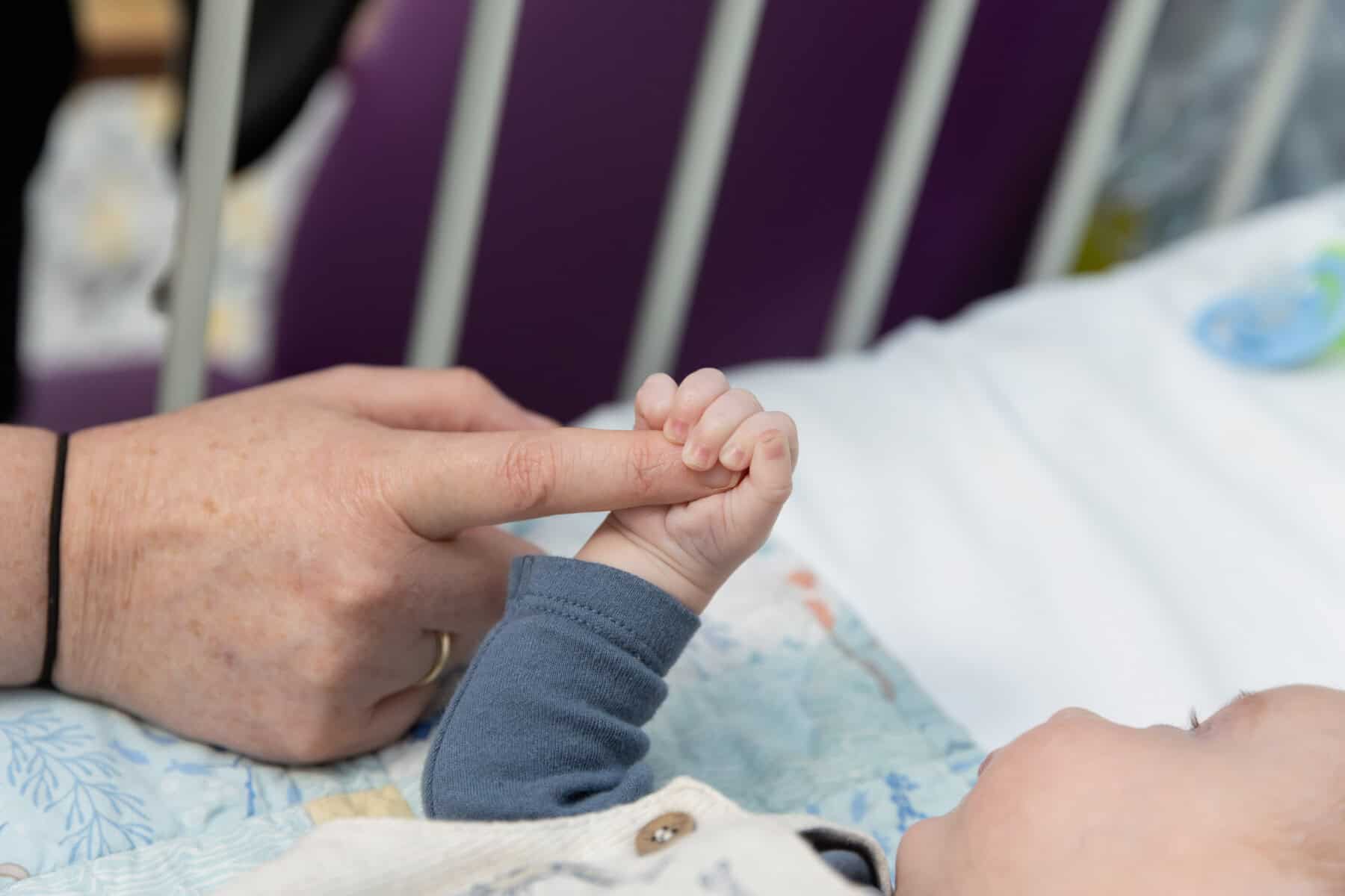 Baby holding parents hand