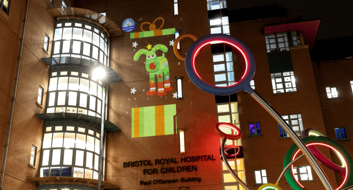 A projection of the Gromit Unleashed sculpture, Noël, lighting up Bristol Children's Hospital.