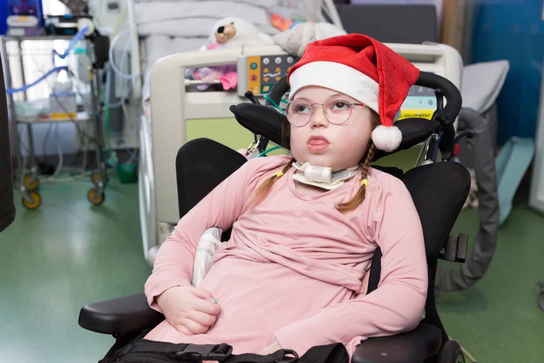A young patient in a Christmas hat.