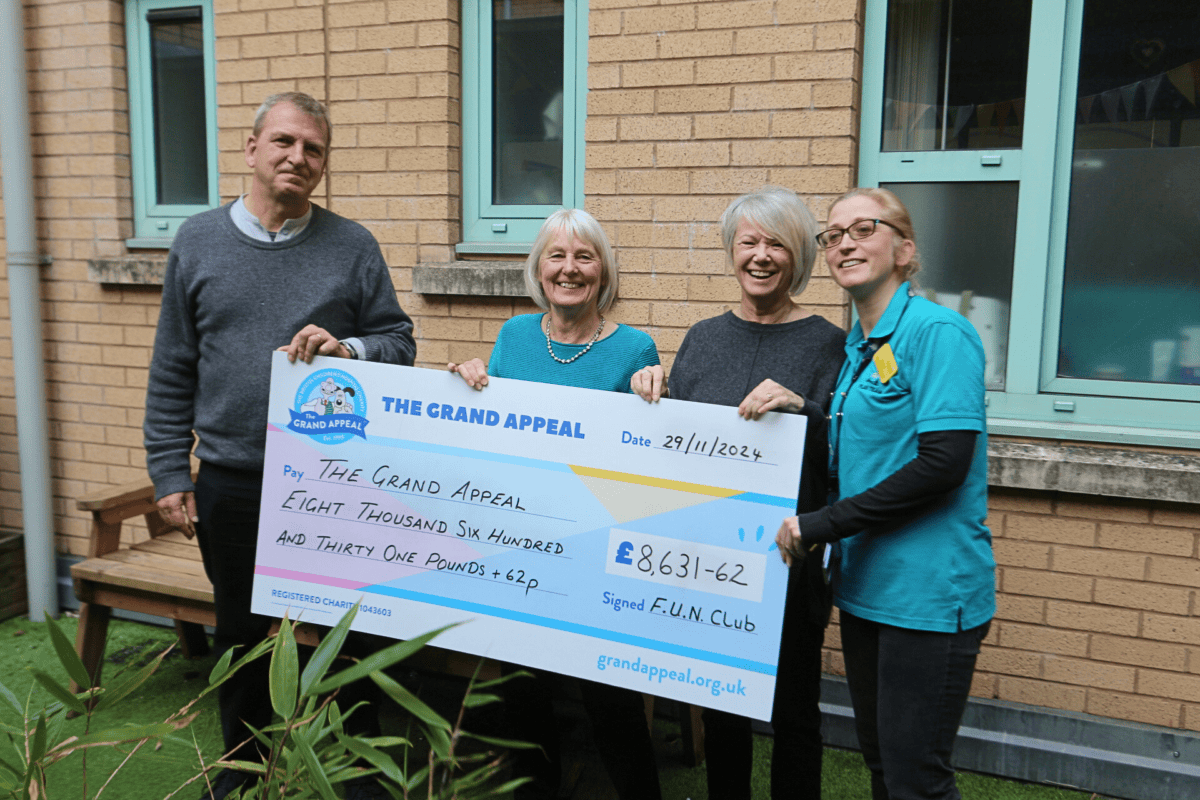 Four people holding a giant cheque.
