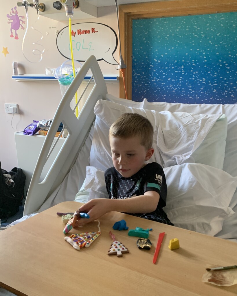 Young patient at Bristol Children's Hospital enjoying Christmas crafts from his hospital bed.
