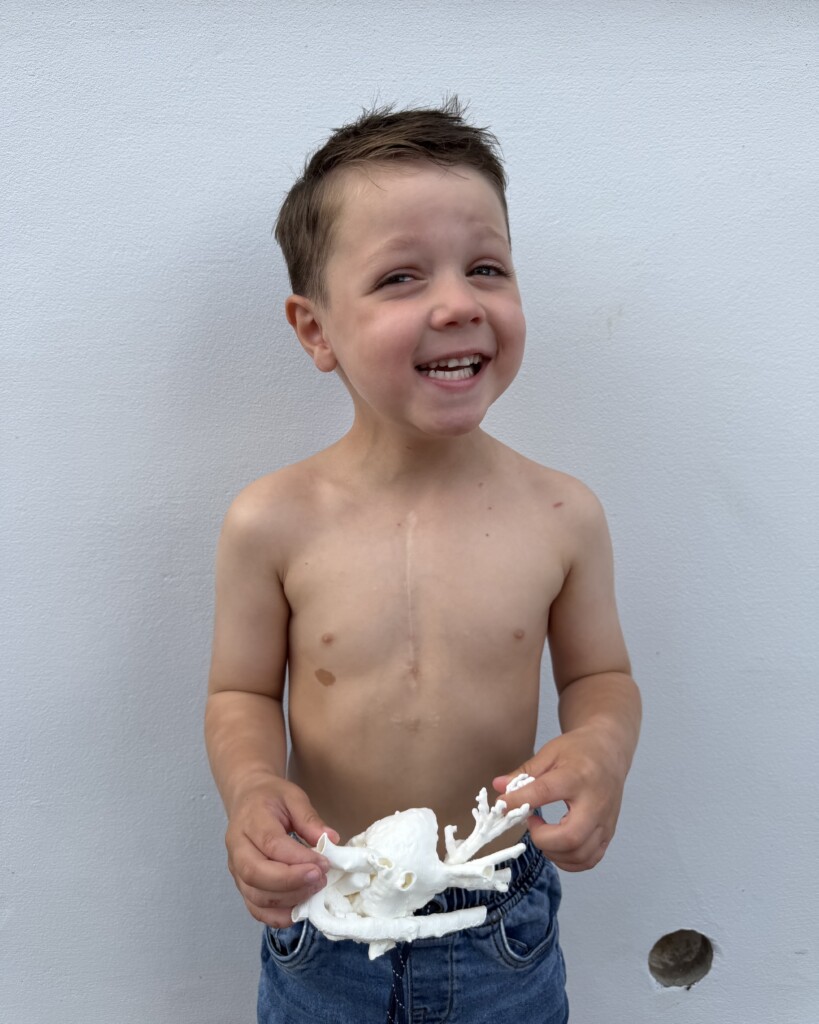 Miles holding a model of his heart, made possible through The Grand Appeal's 3D Printing Service.